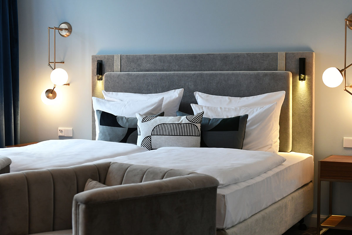 Luxurious bed with soft pillows and warm lighting for restful nights in the junior suite at Hotel Elephant.