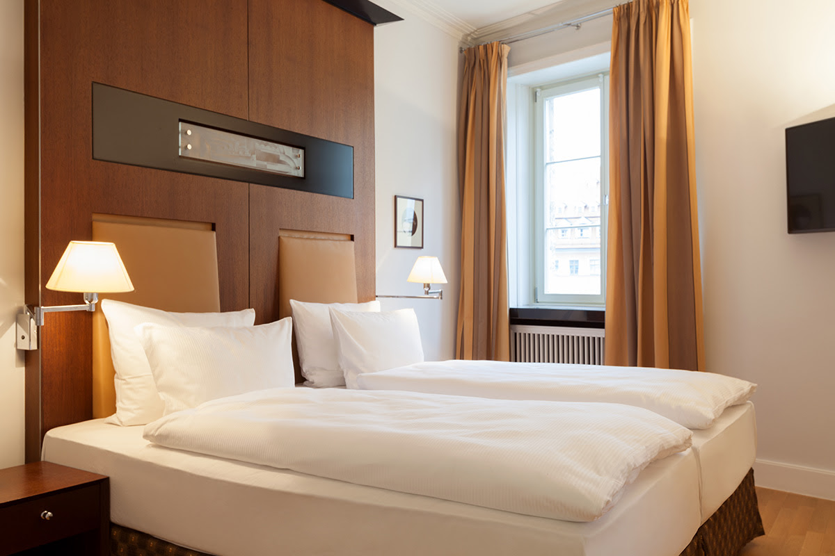 Relaxing ambience in the sleeping area with high-quality bed in the Thomas Mann Suite at the Hotel Elephant Weimar.