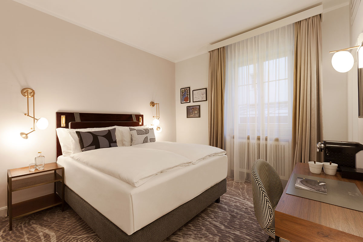 Classic-Zimmer im Hotel Elephant mit elegantem Design, gemütlichem Bett und harmonischer Atmosphäre für Erholung und Inspiration.