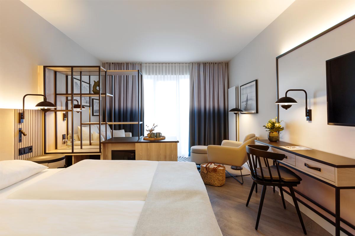 Modern hotel room at the Hotel Kaiserhof Heringsdorf with double bed and cozy sitting area, perfect for the spring special.