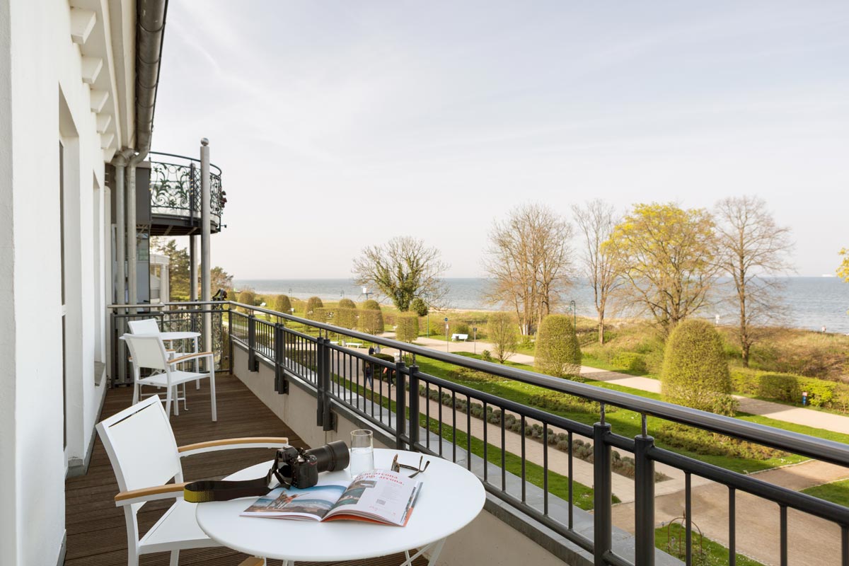 Balkon der Themensuite mit Blick auf die Ostsee, ausgestattet mit Tisch und Stühlen für gemütliche Stunden im Hotel Kaiserhof.