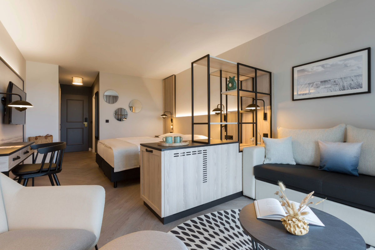 Luxuriöser Schlaf- und Wohnbereich im Deluxe-Zimmer mit Zugang zur Dachterrasse und Ostsee-Aussicht im Hotel Kaiserhof.