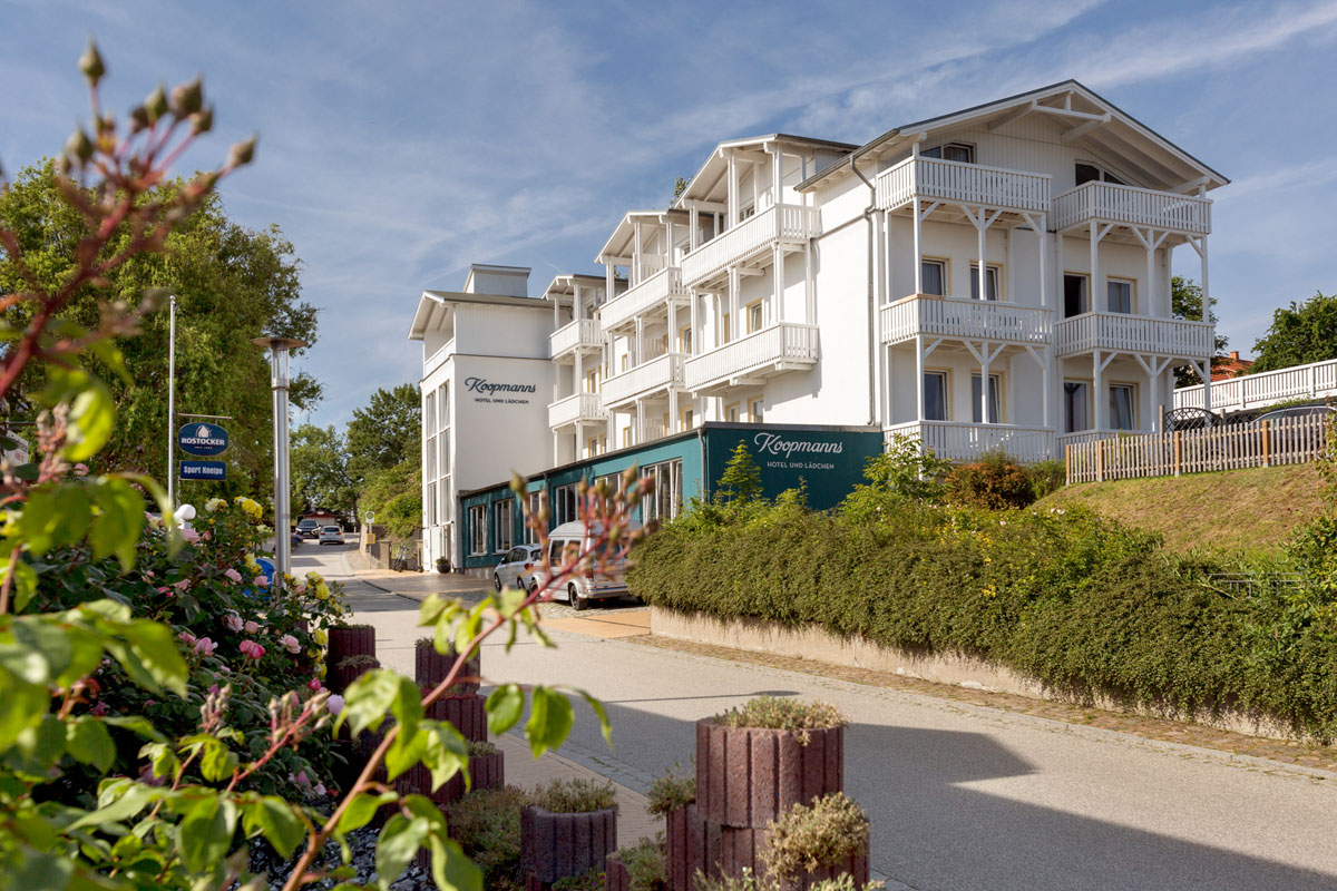 The Koopmanns Hotel &amp; Lädchen on Rügen, surrounded by green nature, with an inviting entrance area and balconies