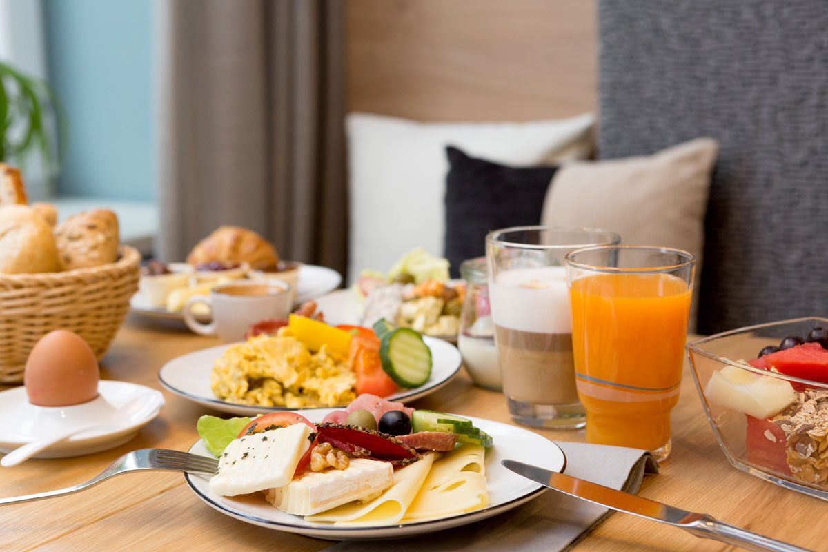 Breakfast table with delicious specialties, orange juice and coffee at Koopmanns Hotel &amp; Lädchen on Rügen.