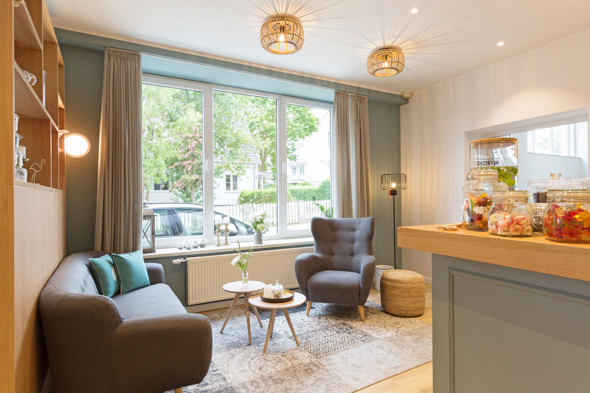 Cozy lounge at Koopmanns Hotel with armchairs, sofas and small tables, ideal for relaxation or snacks.
