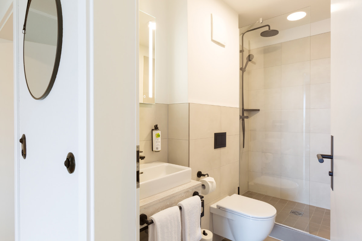 Funktionales und schickes Badezimmer mit Dusche, WC und Spiegel im Komfortdoppelzimmer im Koopmanns Hotel.