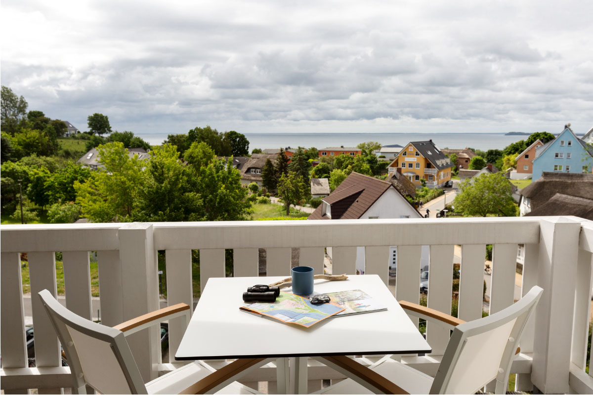 Balkon des Komfort-Doppelzimmers mit Tisch, Stühlen und herrlichem Blick auf die Ostsee im Koopmanns Hotel.