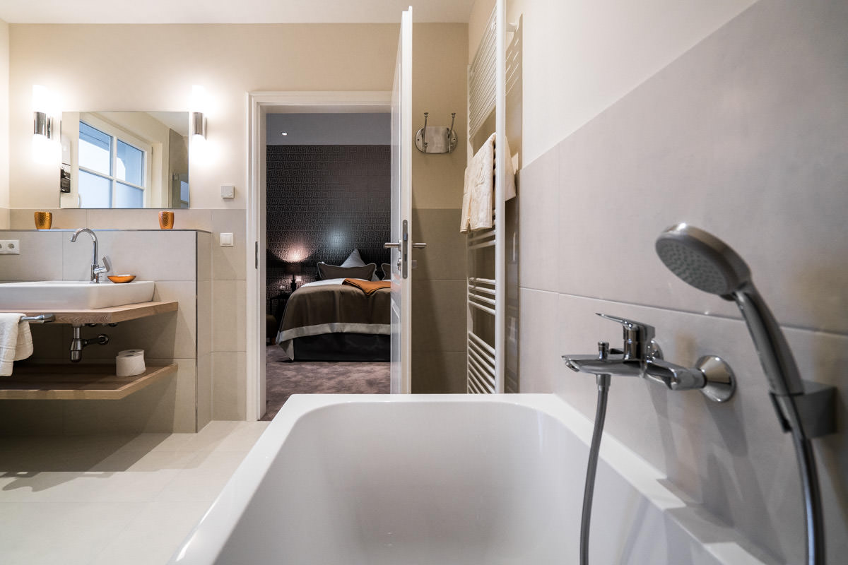 Modern en-suite bathroom with bathtub for relaxation in the vacation home Ostseeperle of the Hotel Künstlerquartier Seezeichen.