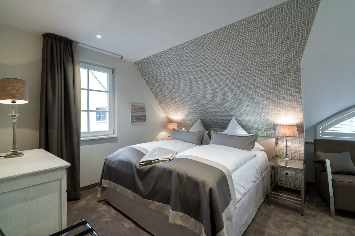 Comfortable bedroom with large double bed in the Ostseeperle vacation home at Hotel Künstlerquartier Seezeichen.