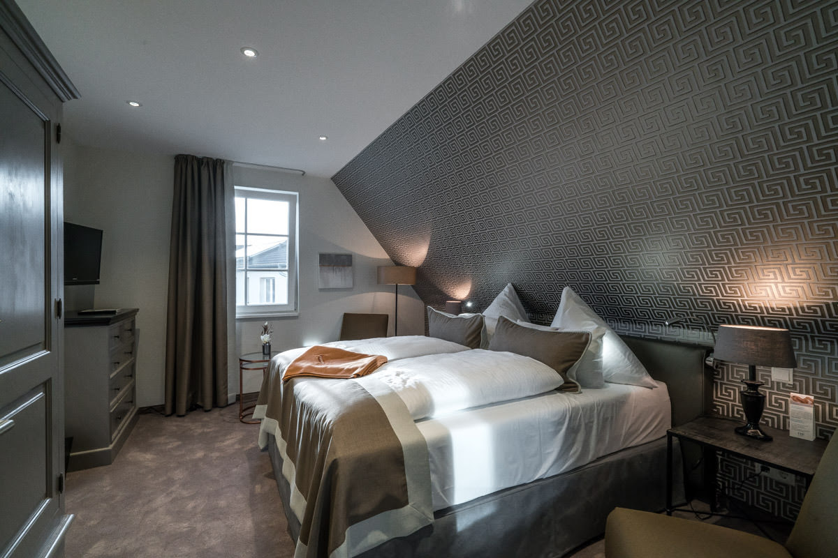 Cozy bedroom with modern design and double bed in the vacation home Ostseeperle of the Hotel Künstlerquartier Seezeichen.