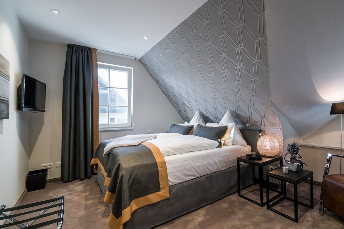 Schlafzimmer im Ferienhaus Seewind mit großem Doppelbett und moderner Einrichtung vom Hotel Künstlerquartier Seezeichen.