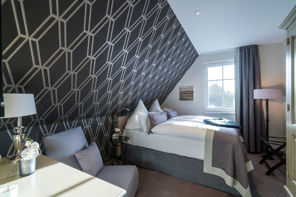 Comfortable bedroom in the Sonneninsel vacation home, part of the Hotel Künstlerquartier Seezeichen, with large bed.