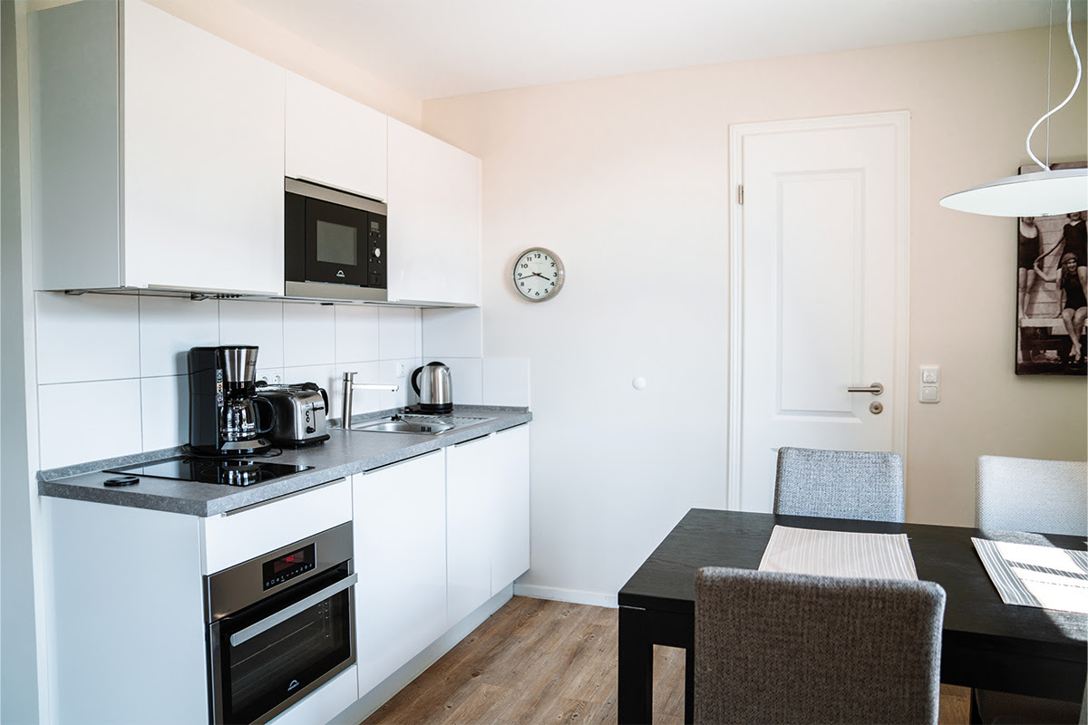 Bright, fully equipped kitchenette in the Dünenpark vacation apartment at Hotel Künstlerquartier Seezeichen.
