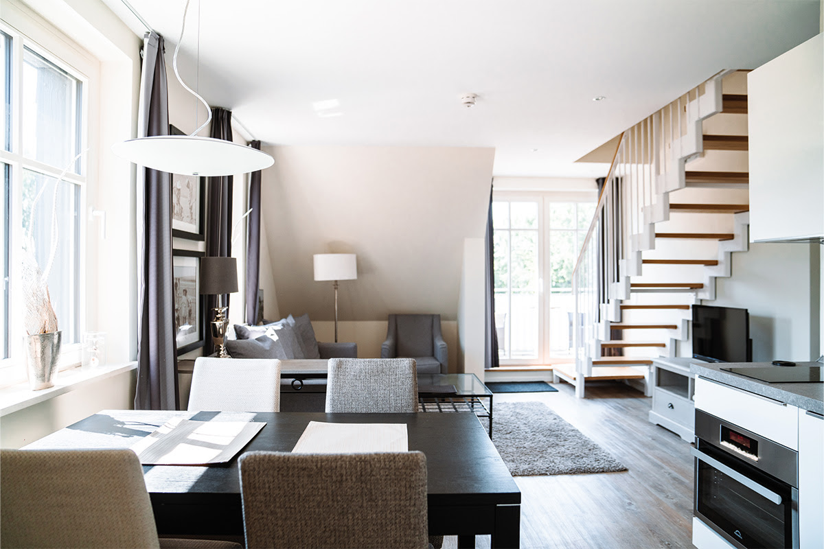 Elegant interior of the Dünenpark vacation apartment with modern living and dining area, part of the Hotel Künstlerquartier Seezeichen.