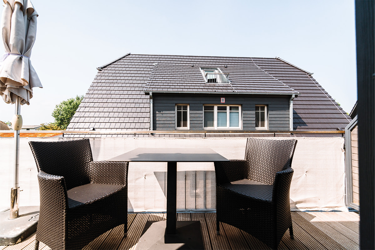 Privater Balkon in der Ferienwohnung Seeigel, ausgestattet mit gemütlicher Sitzgelegenheit im Hotel Künstlerquartier Seezeichen.