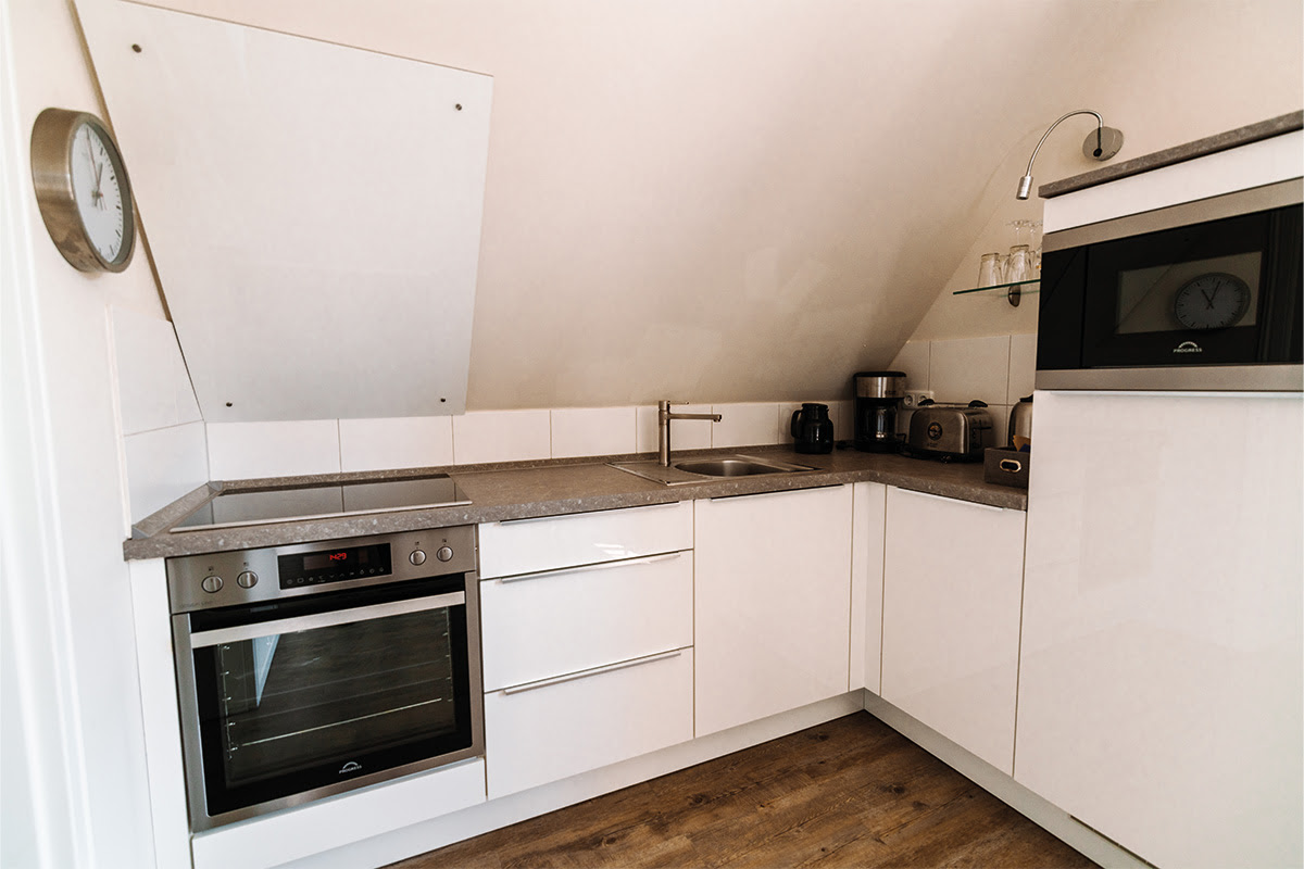 Helle und gut ausgestattete Küche in der Ferienwohnung Seeigel, perfekt für entspanntes Kochen im Hotel Künstlerquartier Seezeichen.