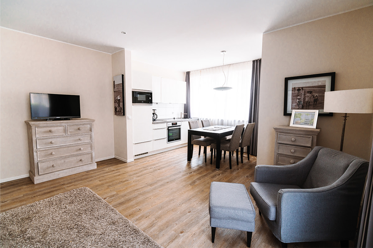 Modern vacation apartment Stranddistel with dining area, open kitchen and stylish furniture in the Hotel Künstlerquartier Seezeichen.