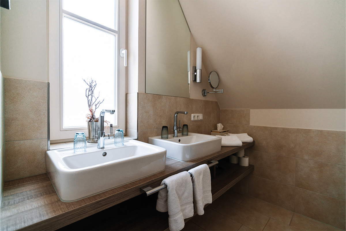 Bathroom with double washbasin, modern fittings and mirror in the Stranddüne vacation apartment in the Ahrenshoop dune park.