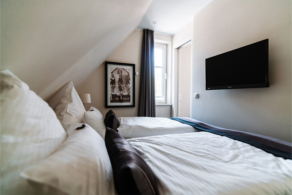 Double bed in the modern bedroom in the Stranddüne vacation apartment in the Hotel Künstlerquartier Seezeichen.