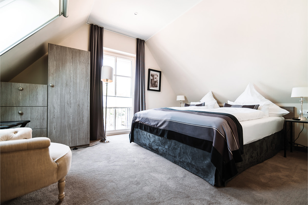 Modern furnished bedroom with cozy bed in the Strandduene vacation apartment in the Hotel Künstlerquartier Seezeichen.