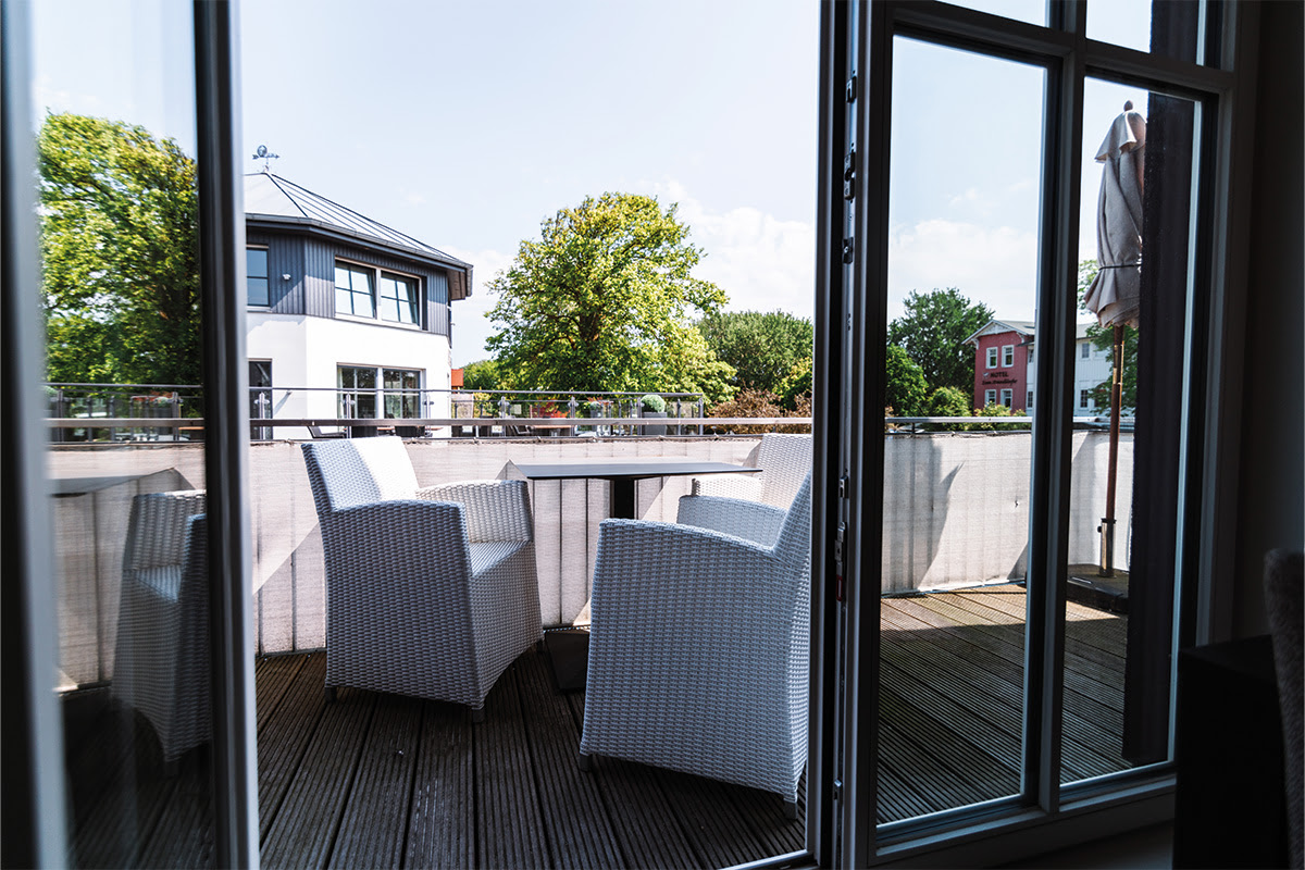 Privater Balkon mit Rattan-Möbeln der Ferienwohnung Strandnixe im Dünenpark des Hotels Künstlerquartier Seezeichen.