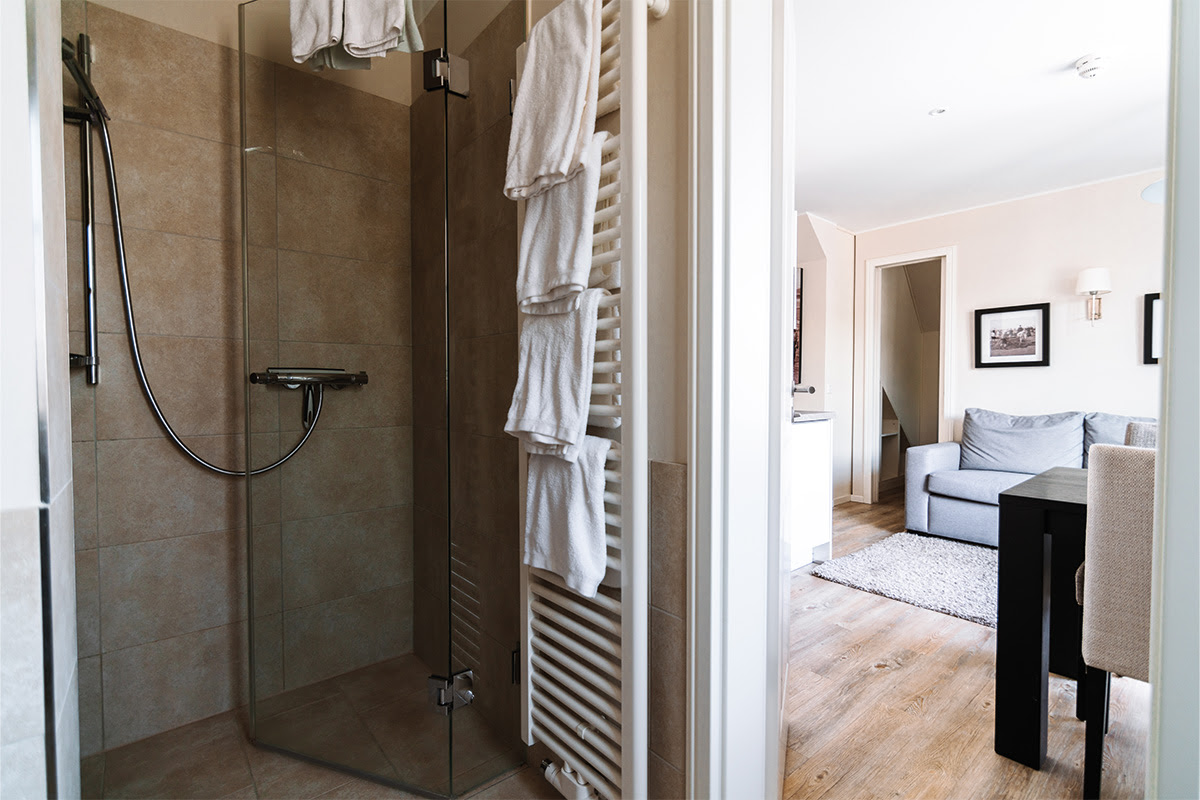 Elegante Glasdusche mit weichen Handtüchern in der Ferienwohnung Strandnixe im Hotel Künstlerquartier Seezeichen.