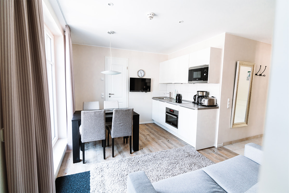 Praktische Küchenzeile und Essbereich in der Ferienwohnung Strandnixe im Hotel Künstlerquartier Seezeichen.