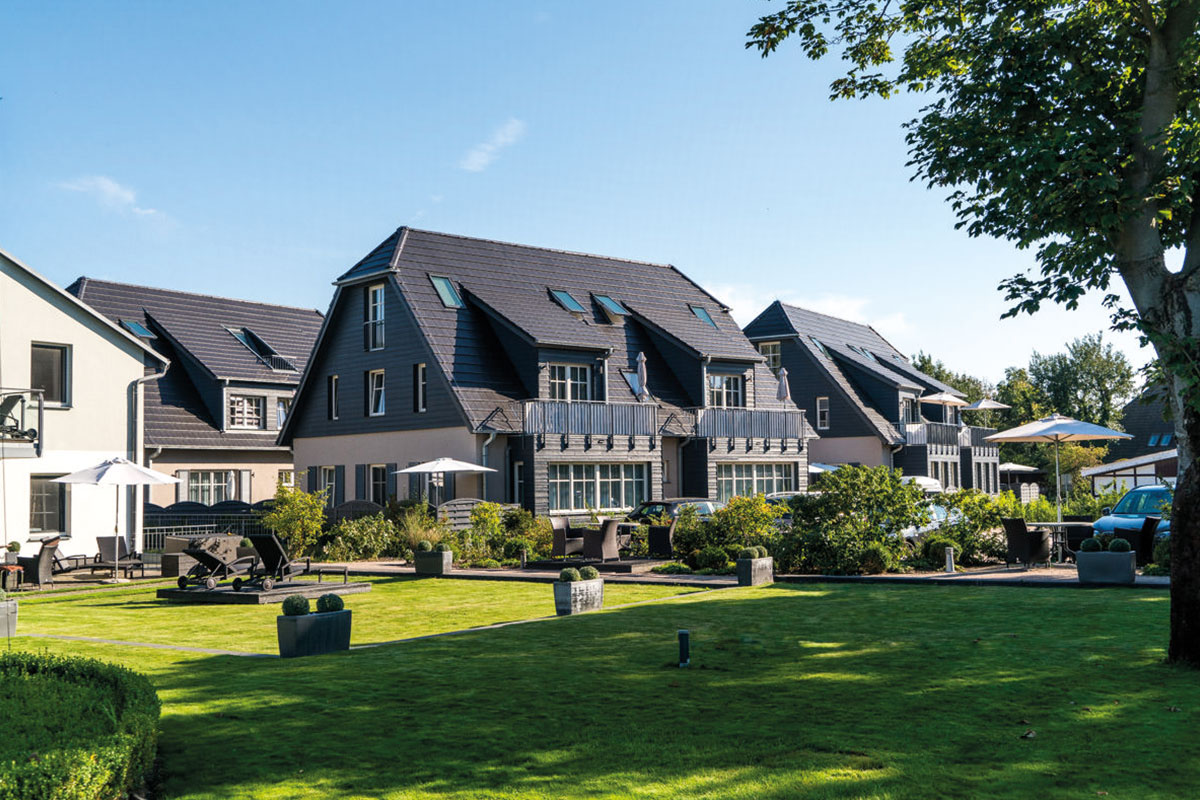 View of the well-kept vacation resort Dünenpark with green garden area, part of the Hotel Künstlerquartier Seezeichen.