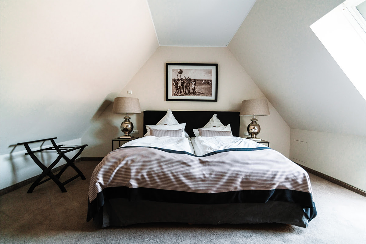 Cozy bedroom with double bed in the Strandperle vacation apartment, part of the Künstlerquartier Seezeichen hotel.