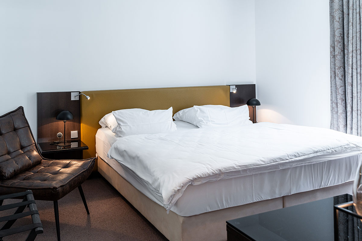 Modernes Schlafzimmer mit großem Doppelbett in der Ferienwohnung Seeschwalbe im Hotel Künstlerquartier Seezeichen.