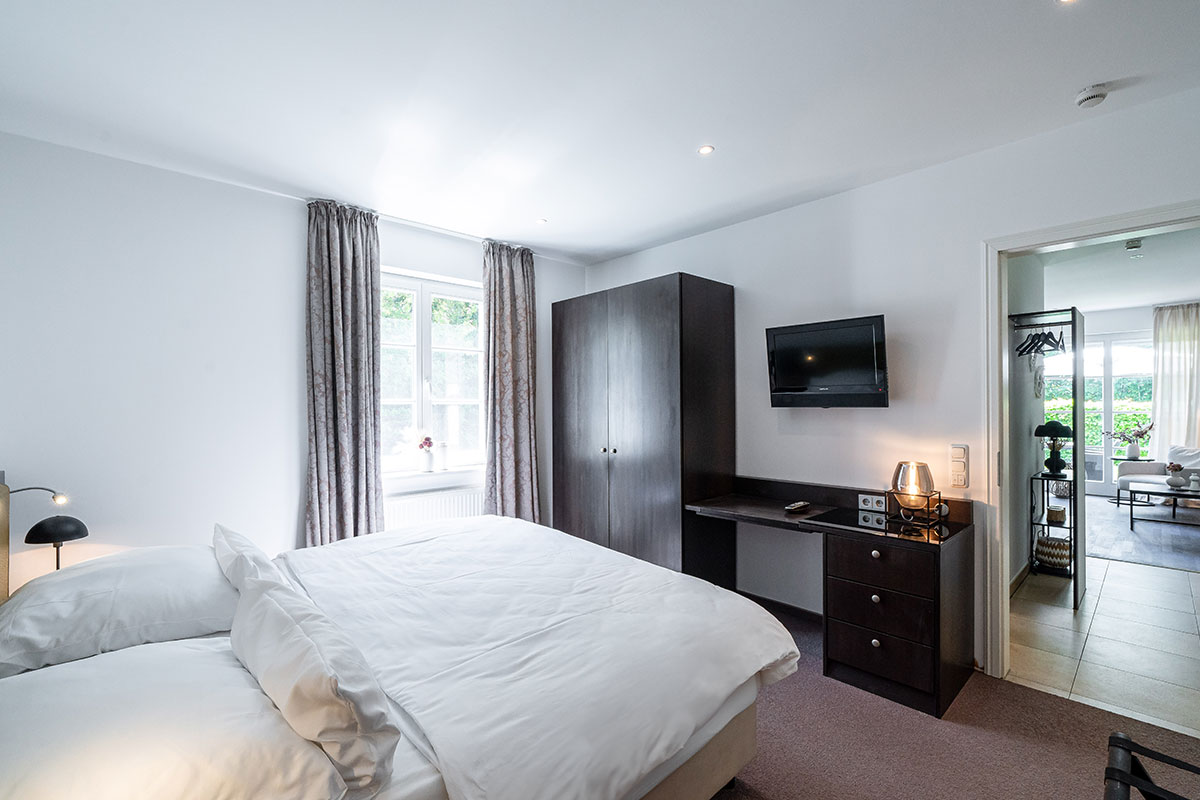 Modern eingerichtetes Schlafzimmer mit Doppelbett mit großem Fenster in der Ferienwohnung Seeschwalbe in der Residenz in Ahrenshoop.