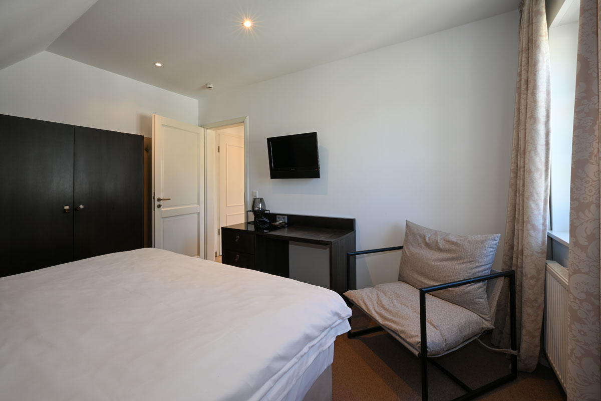Modern bedroom with double bed and large closet in the Seestern vacation apartment in the Hotel Künstlerquartier Seezeichen.