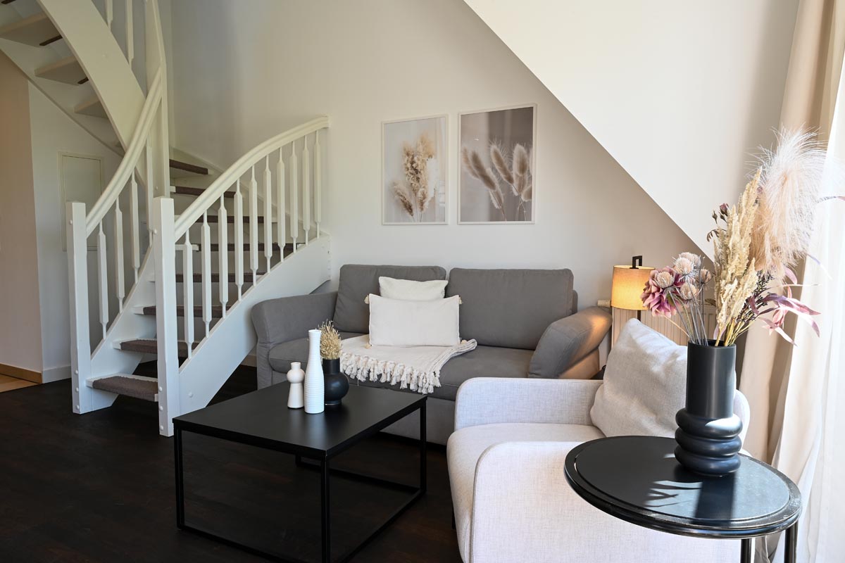 Tastefully furnished living room of the Seestern vacation apartment in the Hotel Künstlerquartier Seezeichen next to your staircase.