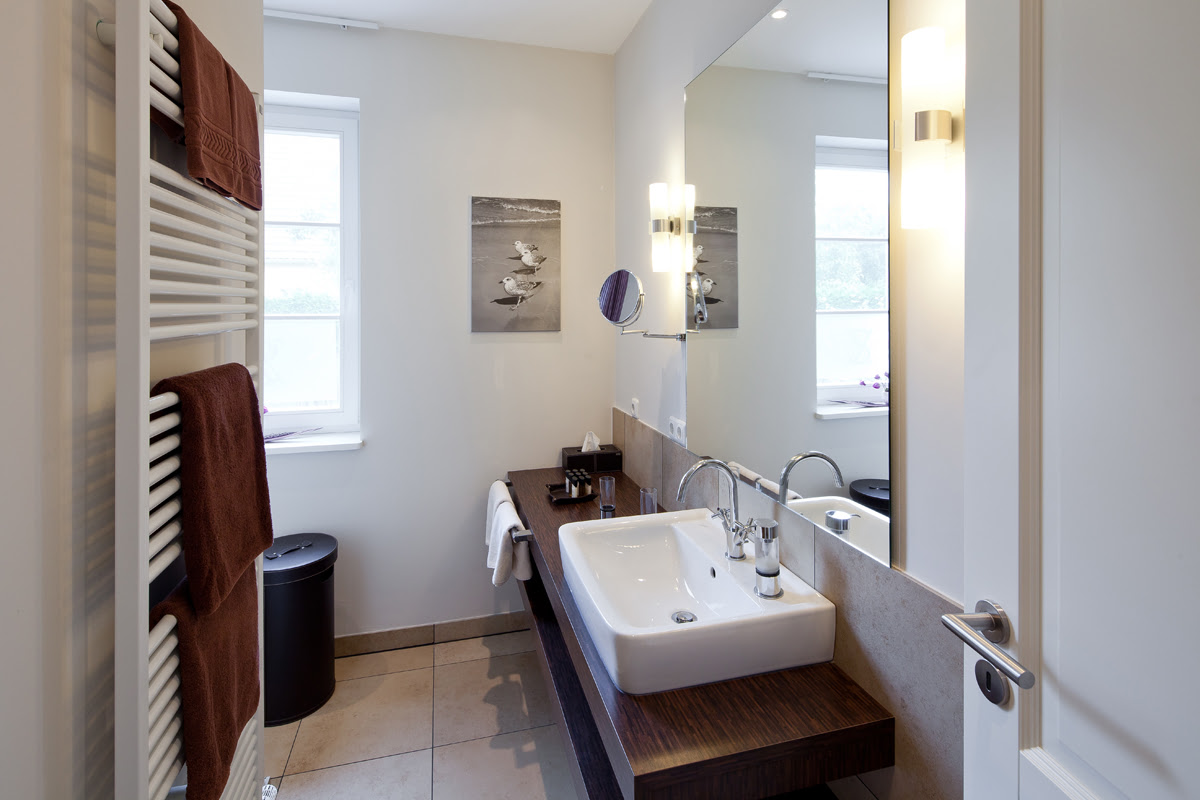 Bright bathroom with plenty of storage space in the Strandmöwe vacation apartment in the Hotel Künstlerquartier Seezeichen.