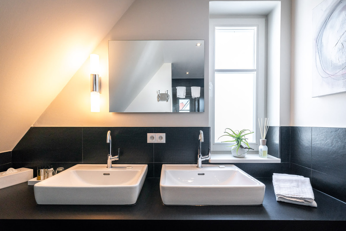 Modernes Bad mit Doppelwaschbecken und Tageslicht in der Ferienwohnung Strandjuwel im Hotel Künstlerquartier Seezeichen.