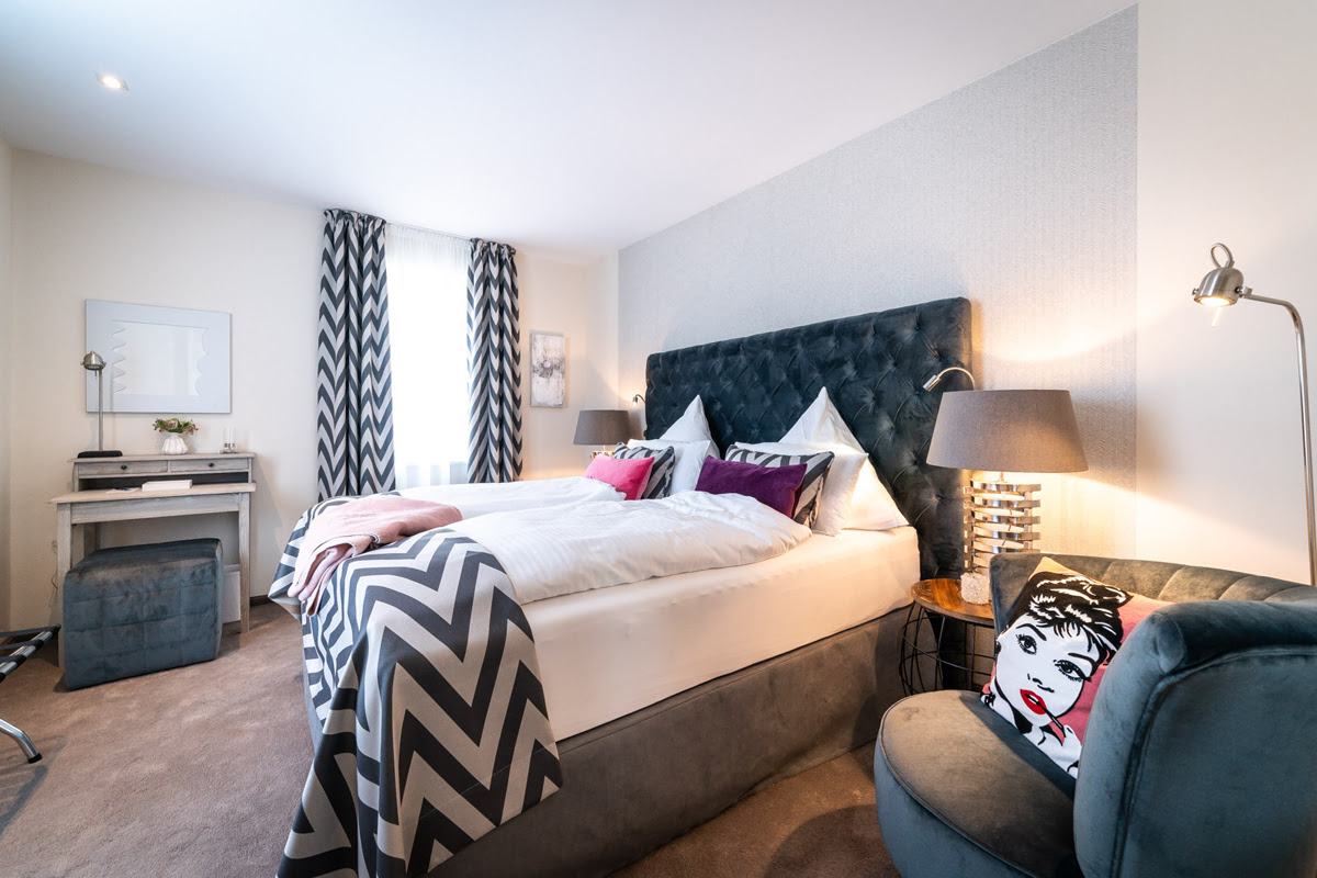 Stylish bedroom with box-spring bed and decorative accents in the Strandliebe vacation apartment in the Künstlerquartier Seezeichen.