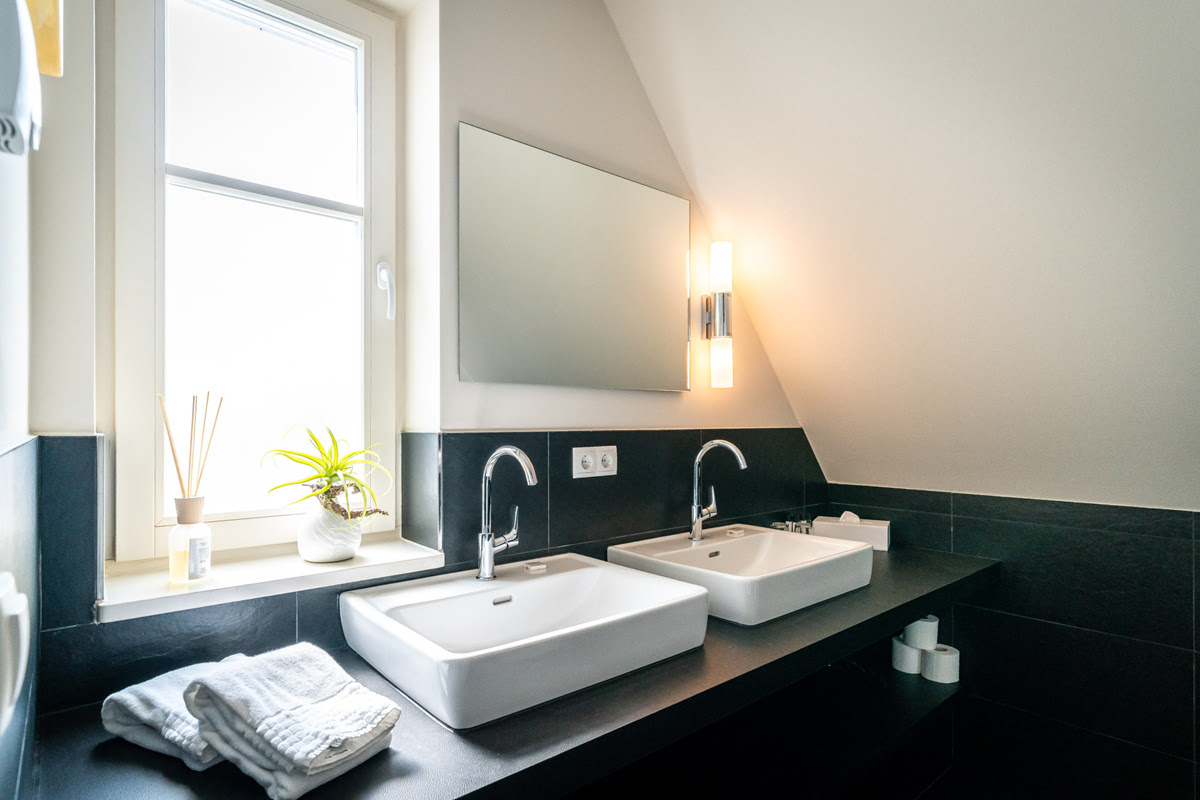 Modern bathroom in the Strandoase vacation apartment in the Hotel Künstlerquarter Seezeichen with luxurious double washbasin.
