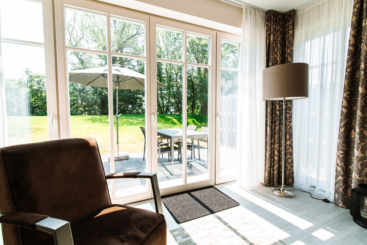 View of the garden, terrace and parasol through the patio door of the Strandtraum vacation apartment in Ahrenshoop.