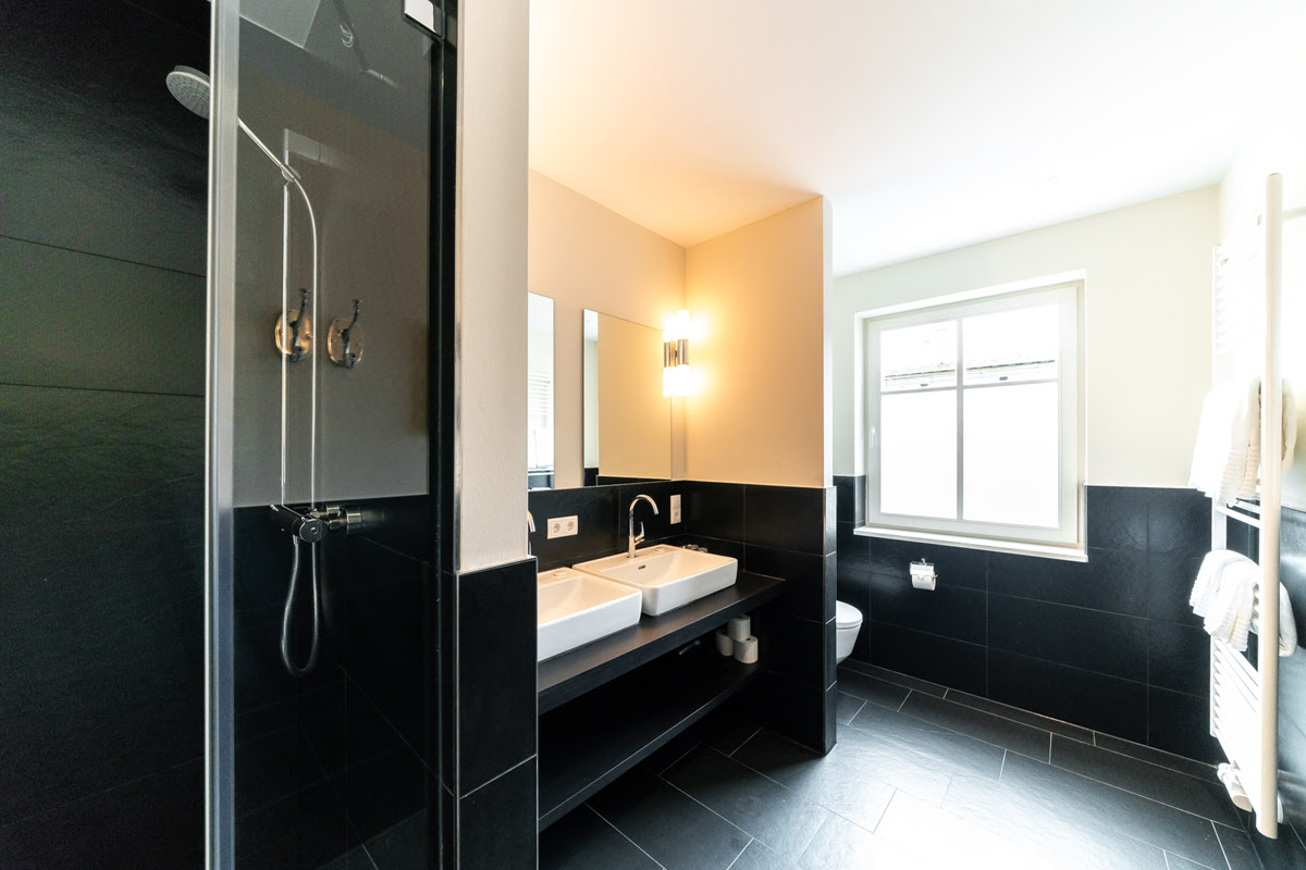 Spacious bathroom with rain shower, double washbasin and daylight in the Strandtraum vacation apartment in Ahrenshoop.