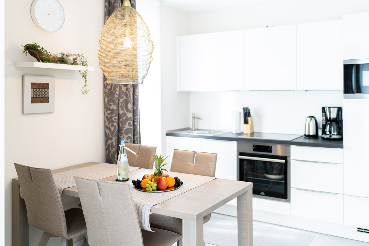 Kitchenette with dining table, fruit arrangement and modern furnishings in the Strandtraum vacation apartment at the Künstlerquartier Seezeichen.