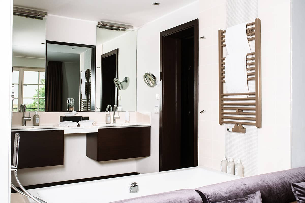 Modern bathroom with double washbasin and large bathtub in the Deluxe Suite in the Hotel Künstlerquartier Seezeichen.