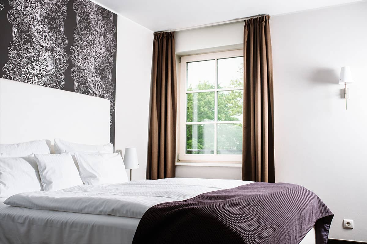 Bedroom of the Deluxe Suite in the Hotel Künstlerquartier Seezeichen with large double bed and wall decoration.