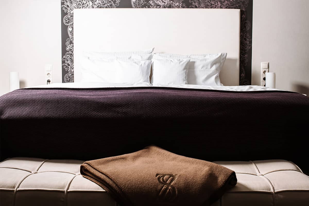 High-quality bed with upholstered headboard in the Deluxe Suite in the Hotel Künstlerquartier Seezeichen on the Baltic Sea.