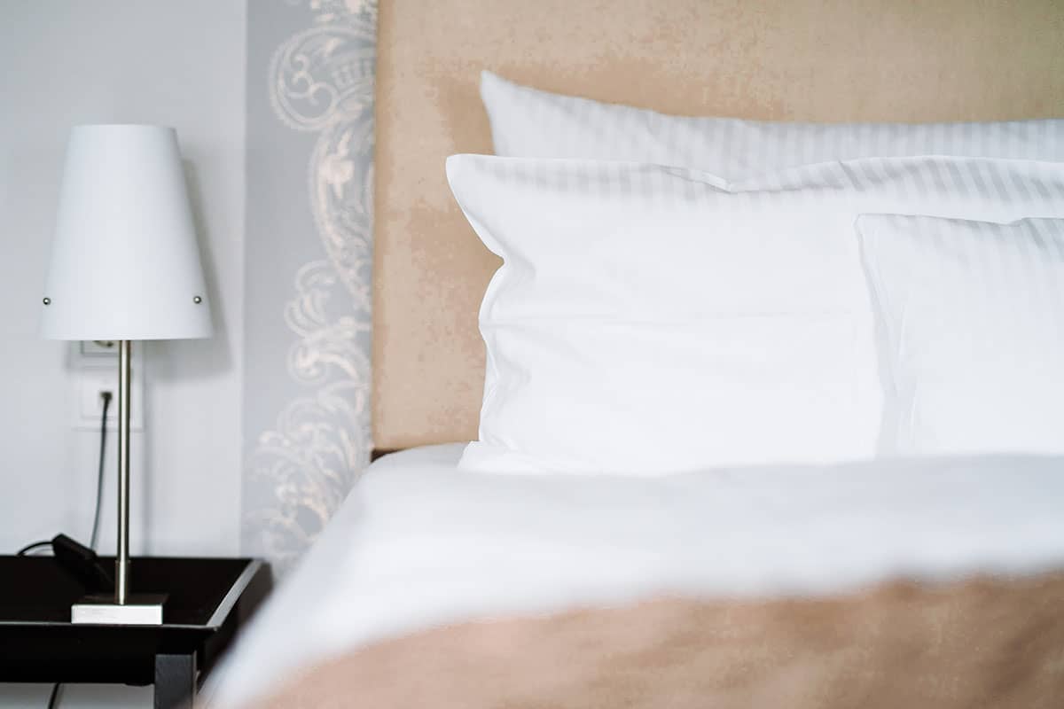 Gmütliches Bett mit weichen Kissen im Schlafzimmer der Junior Suite des Hotel Künstlerquartier Seezeichen.