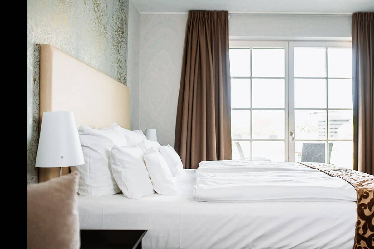 Großes Bett mit weichen Kissen im Schlafzimmer der Junior Suite des Hotel Künstlerquartier Seezeichen.