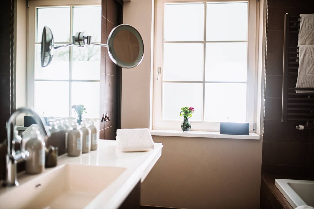 Badezimmer in der Junior Suite des Hotel Künstlerquartier Seezeichen mit großem Spiegel, Waschbecken und Pflegeprodukten.