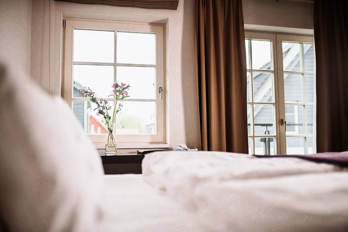 Ausblick aus dem Comfort-Doppelzimmer auf die malerischen Dächer von Ahrenshoop im Hotel Künstlerquartier Seezeichen.