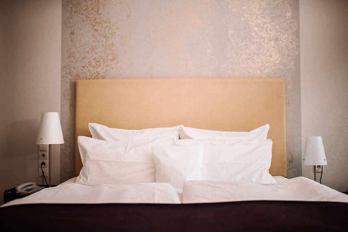 Bequemes Doppelbett mit weicher Bettwäsche im Comfort Doppelzimmer des Hotel Künstlerquartier Seezeichen.