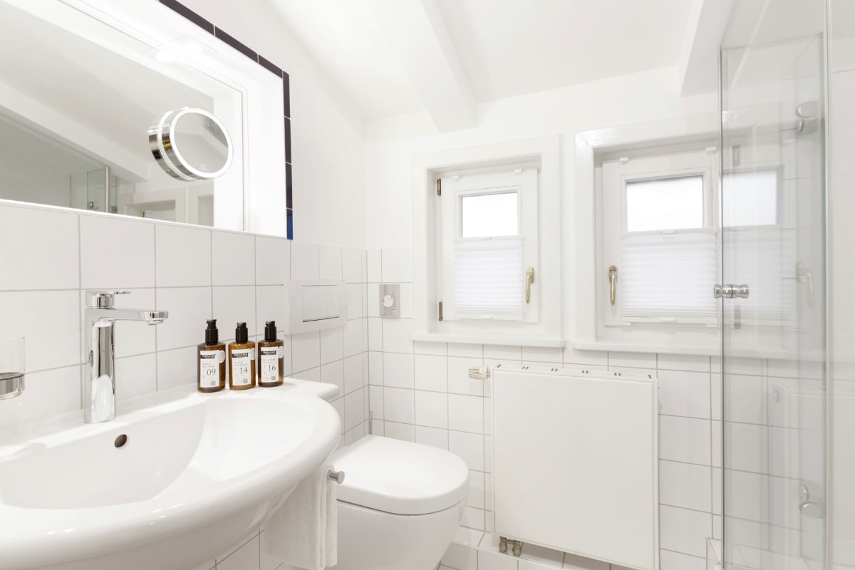Badezimmer mit Dusche, Waschbecken und hochwertiger Ausstattung im Einzelzimmmer des Elisabeth von Eicken Hotel.