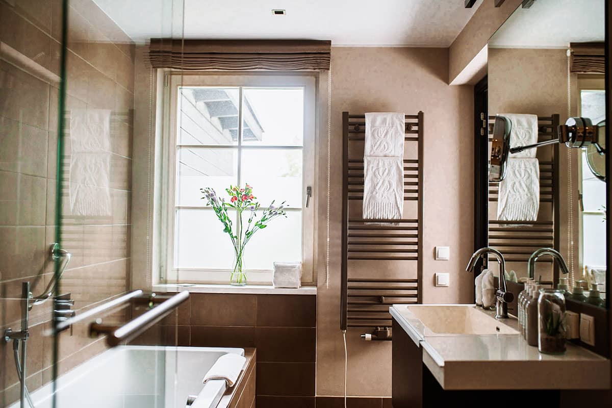 Modernes Badezimmer im First-Class-Doppelzimmer des Hotel Künstlerquartier Seezeichen mit Badewanne und Waschbecken.